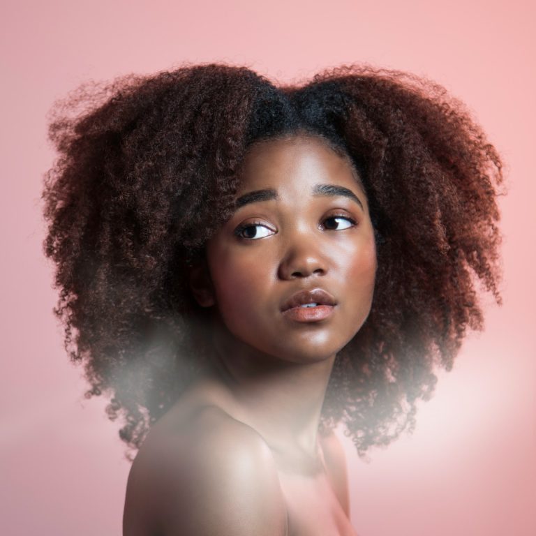 Femme aux cheveux crépus naturels, soin fortifiant à la mélasse noire